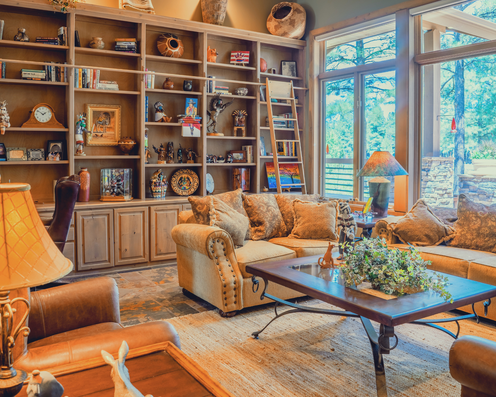 Southwestern-style den with curated bookshelves, pottery and tufted leather armchairs