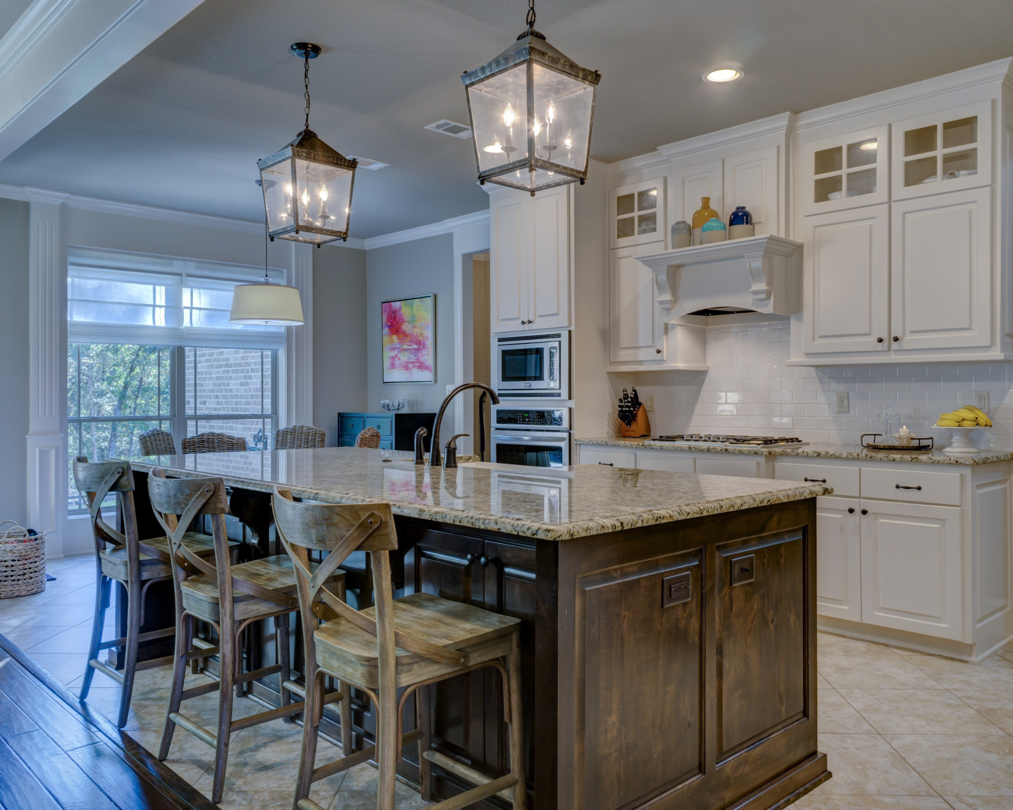 Farmhouse kitchen with a granite island, lantern pendants and shaker cabinetry
