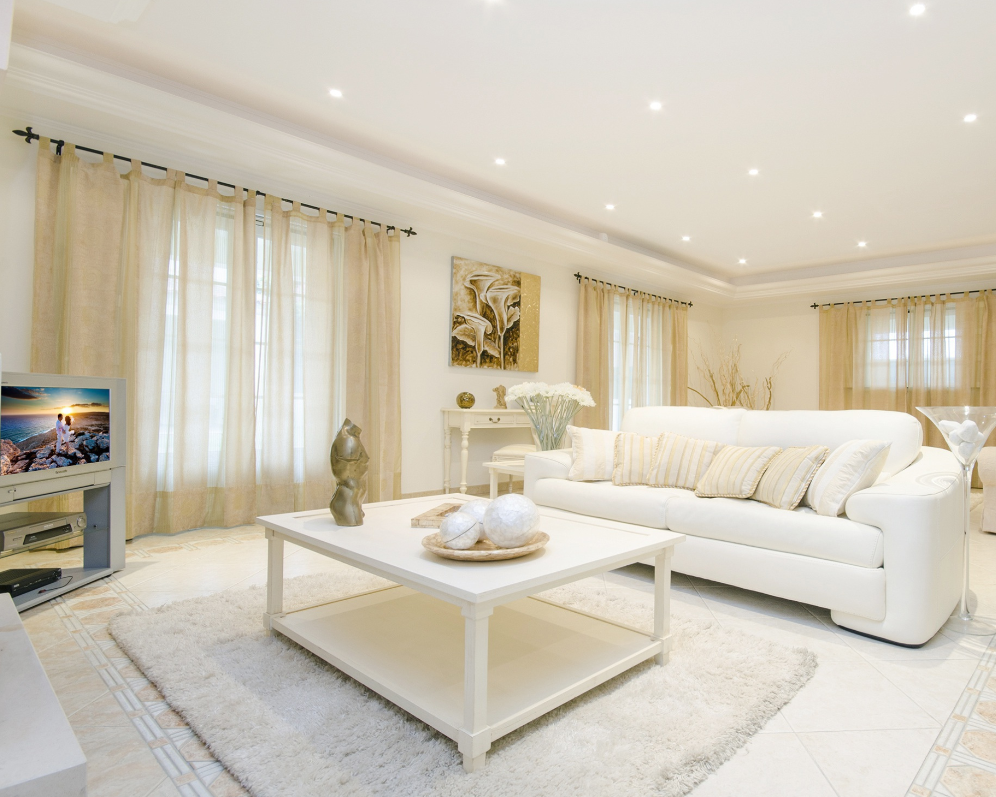 Cream glam living room with an ivory leather sofa and botanical artwork