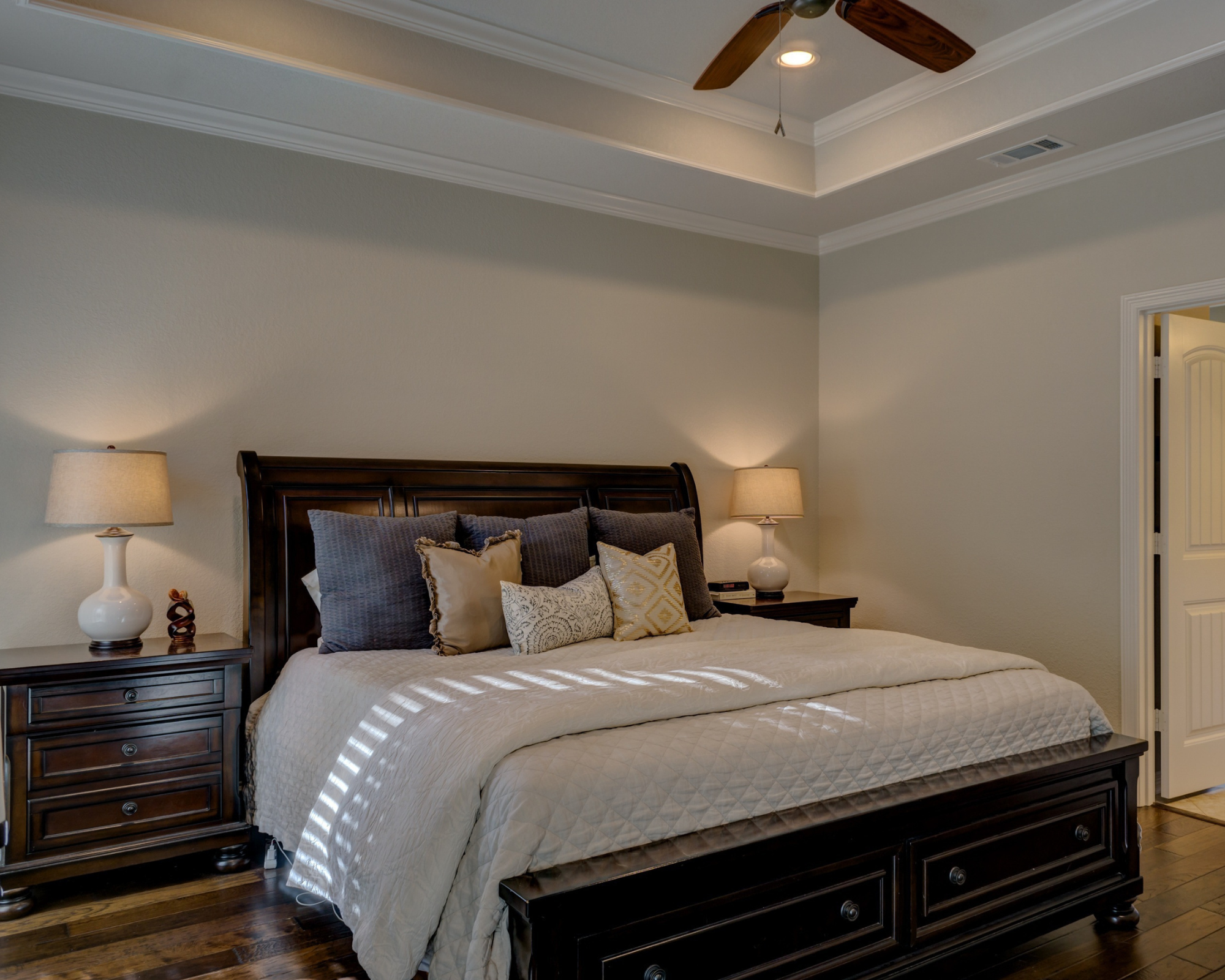 Traditional master bedroom with a dark wood sleigh bed and tailored linens